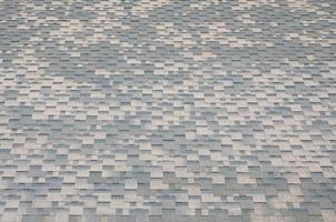 Background mosaic texture of flat roof tiles with bituminous coating photo