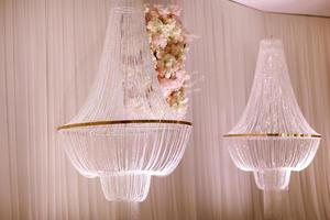 festive wedding decoration with crystal chandeliers and white pink flowers . stylish wedding day photo