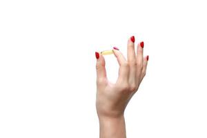 Hand holding capsule of Omega 3 on white background. Close up. High resolution product. Health care concept photo