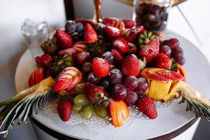 mesa de banquete de catering bellamente decorada con diferentes frutas frescas en un evento de fiesta de cumpleaños corporativo o celebración de bodas foto