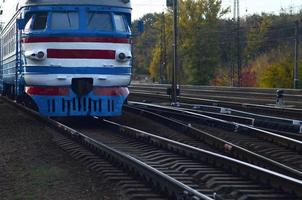 Old soviet electric train with outdated design moving by rail photo