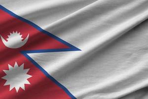 Nepal flag with big folds waving close up under the studio light indoors. The official symbols and colors in banner photo