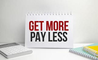 get more pay less words on paper notebook with office supplies photo