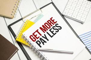 get more pay less . Conceptual background with chart ,papers and pen photo