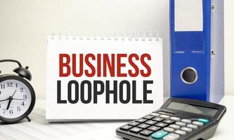 business loophole words on yellow sticker with calculator and paper folder photo