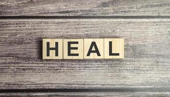 heal words on wooden blocks and brown background photo