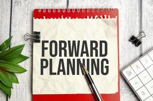 red notebook, forward planning words and white background photo
