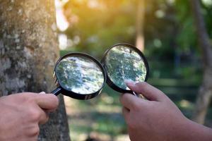 Two small black magnifying glasses holding in hands and were used during the summer camp to study microorganisms in plants and plants diseases. photo