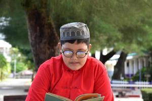 Portrait young southeast asian islamic or muslim boy in white shirt and hat, isolated on white, soft and selective focus. photo