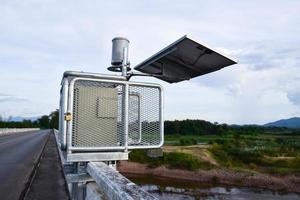 sistema de celdas solares para almacenar y ahorrar energía para usar con pluviómetros y sistema de advertencia de inundaciones cerca del puente. foto