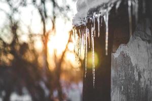 invierno, carámbanos colgando del techo, puesta de sol foto