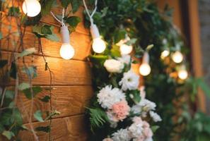 beautiful bouquets of flowers on the background of a wooden board and garlands photo