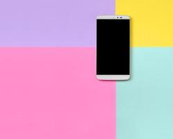 Modern smartphone with black screen on texture background of fashion pastel blue, yellow, violet and pink colors paper in minimal concept photo