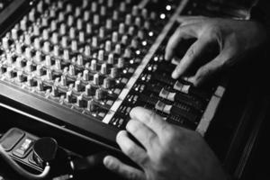 the sound engineer works at the mixing console mixing the musical composition on the recording. photo