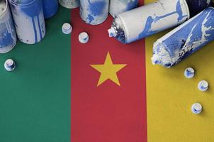 Cameroon flag and few used aerosol spray cans for graffiti painting. Street art culture concept