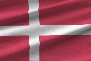 Denmark flag with big folds waving close up under the studio light indoors. The official symbols and colors in banner photo