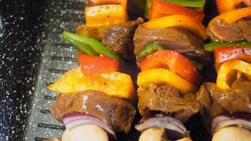 kebabs de ternera marinada con verduras preparadas a la parrilla. el cocinero voltea la carne para freír en otro lugar video