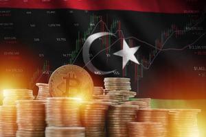 Libya flag and big amount of golden bitcoin coins and trading platform chart. Crypto currency photo
