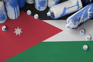 Jordan flag and few used aerosol spray cans for graffiti painting. Street art culture concept photo