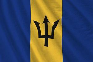 Barbados flag with big folds waving close up under the studio light indoors. The official symbols and colors in banner photo