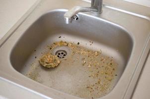 Close up on dirty clogging kitchen sink drain with food particles photo