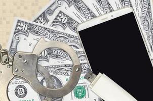 20 US dollars bills and smartphone with police handcuffs. Concept of hackers phishing attacks, illegal scam or malware soft distribution photo