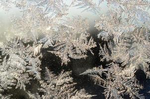 Snowflakes frost rime macro on window glass pane photo