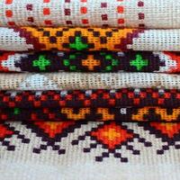 Stack of traditional Ukrainian folk art knitted embroidery patterns on textile fabric photo