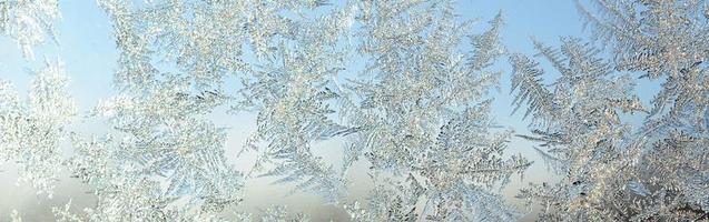 Snowflakes frost rime macro on window glass pane photo