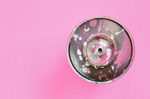 lata de aerosol usada con gotas de pintura rosa se encuentran en el fondo de textura de papel de color rosa pastel de moda en un concepto mínimo foto