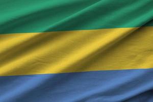 Gabon flag with big folds waving close up under the studio light indoors. The official symbols and colors in banner photo