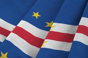 Cabo verde flag with big folds waving close up under the studio light indoors. The official symbols and colors in banner photo