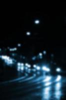 escena nocturna borrosa de tráfico en la carretera. imagen desenfocada de coches que viajan con faros luminosos. arte bokeh foto