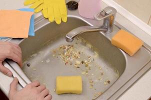 The housekeeper was faced with the problem of washing an overly dirty sink filled with food particles photo