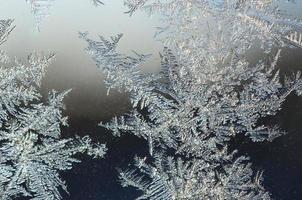 Snowflakes frost rime macro on window glass pane photo