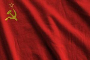 Soviet Union flag with big folds waving close up under the studio light indoors. The official symbols and colors in banner photo