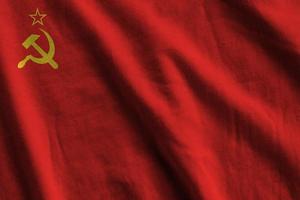 Soviet Union flag with big folds waving close up under the studio light indoors. The official symbols and colors in banner photo