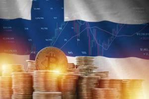 Finland flag and big amount of golden bitcoin coins and trading platform chart. Crypto currency photo