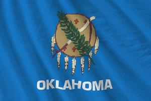 Oklahoma US state flag with big folds waving close up under the studio light indoors. The official symbols and colors in banner photo