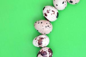 Quail eggs on a light green surface, top view, empty place for t photo