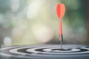 dart arrow hitting in the target center of dartboard,Business targeting and focus concept,the growth and purpose of the organization,Competitive marketing strategy planning management photo