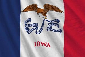 Iowa US state flag with big folds waving close up under the studio light indoors. The official symbols and colors in banner photo