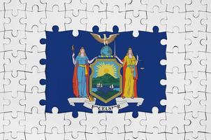 New York US state flag in frame of white puzzle pieces with missing central part photo