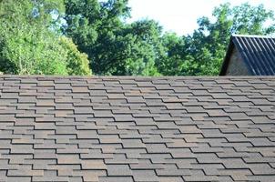 Modern roofing and decoration of chimneys. Flexible bitumen or slate shingles photo