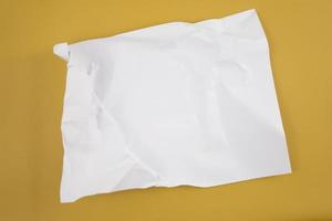Abstract crumpled paper texture isolated in yellow background photo