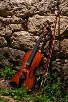 violín y arco cerca de la pared con buena luz foto