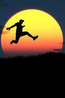 Vertical silhouette of a man jumping to the future. The concept of moving on to something better photo