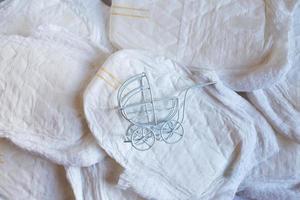 Baby diapers with toy carriage on a white background photo