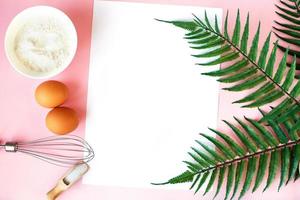 Ingredients for cooking baking - flour, egg, sugar, rolling pin on pink background. Concept of cooking dessert. photo
