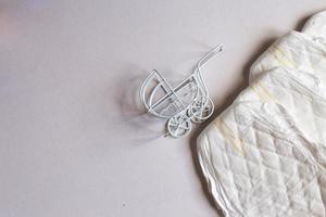 Baby diapers with toy carriage on a white background photo